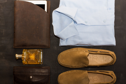 Men's shirt and moccasins on black background, top view